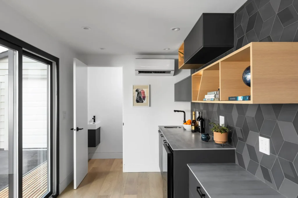 Modern kitchen with black cabinets and open shelves.