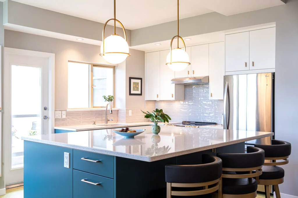 Modern kitchen with island and pendant lights.
