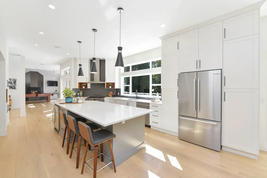 Bright modern kitchen with island and stainless steel appliances.